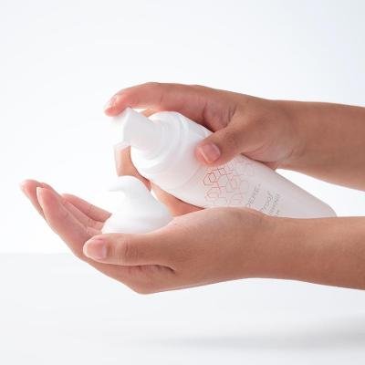 Modere CellProof Body Firming Foam Australia - Image 3 - Shop Shaklee Australia Hands dispensing lotion from a white pump bottle into the palm of the other hand.