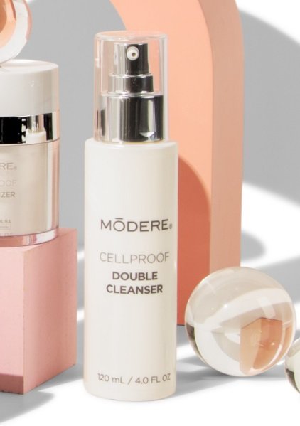Modere CellProof Double Cleanser Australia - Image 4 - Shop Shaklee Australia White Modere Cellproof Double Cleanser bottle with pump, in a pastel-styled makeup and skincare setting.