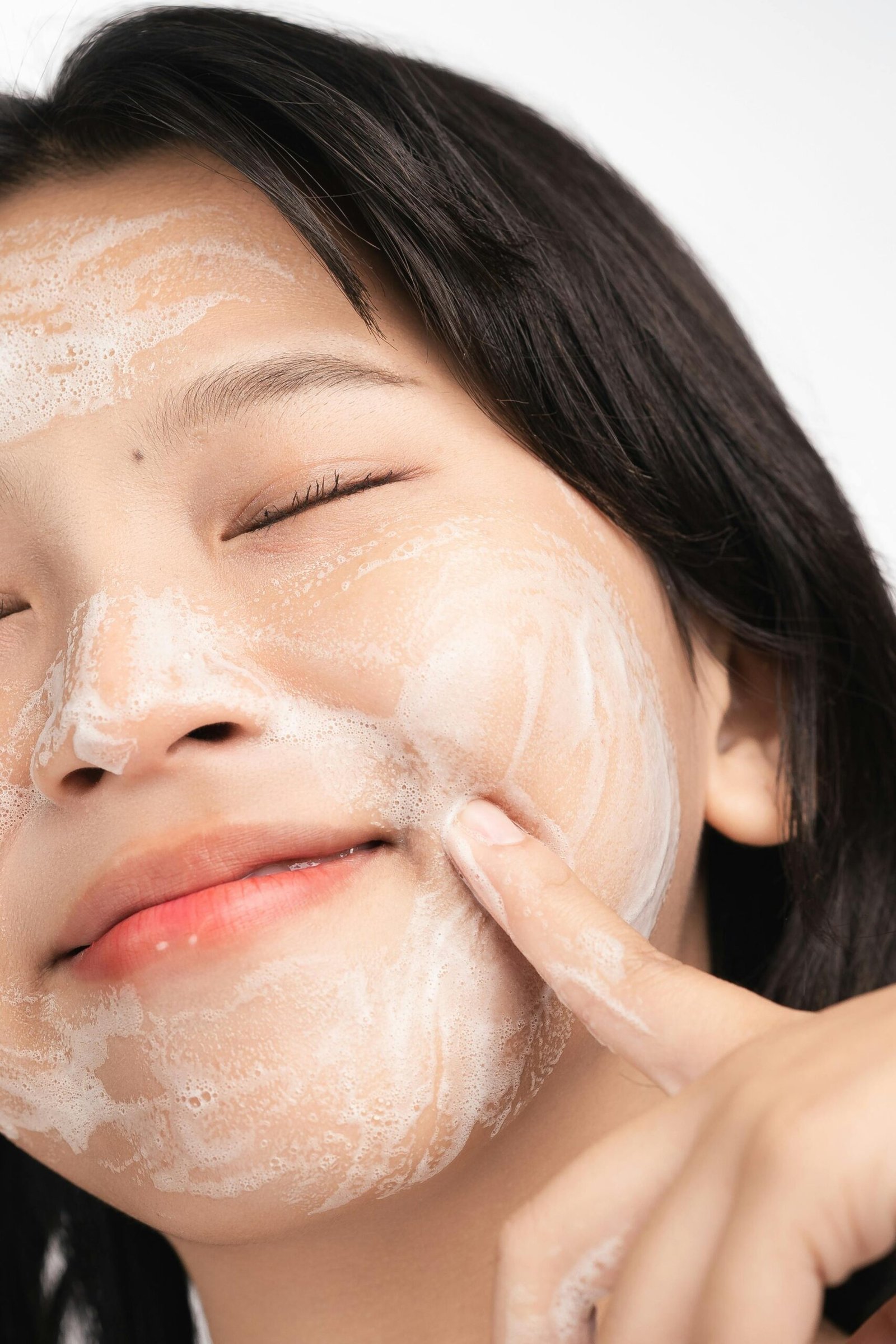 Modere CellProof Double Cleanser Australia - Image 5 - Shop Shaklee Australia Close-up of a woman with foamy cleanser on her face, eyes closed during a skincare cleanse.