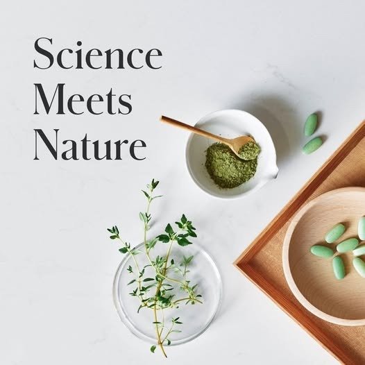 Science Meets Nature: flat lay with herbs, green powder, and capsules on a marble background, conveying a nature-meets-science concept.