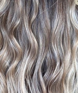 Modere CellProof MicroBond Hair Conditioner Australia - Image 3 - Shop Shaklee Australia Close-up of wavy hair with multi-toned blonde highlights and subtle texture.